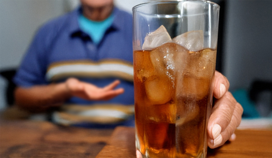 氷の入ったグラスを持つ男性