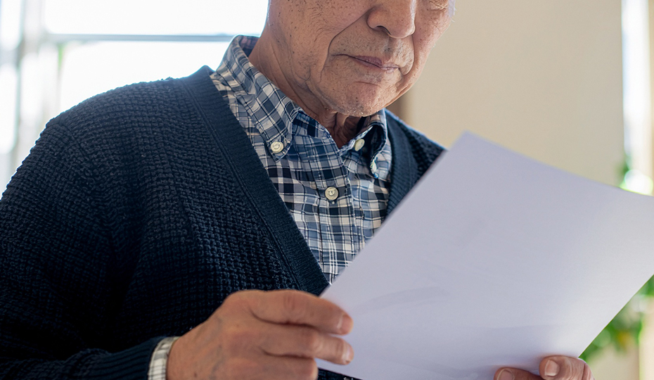 書類を読む老人の画像