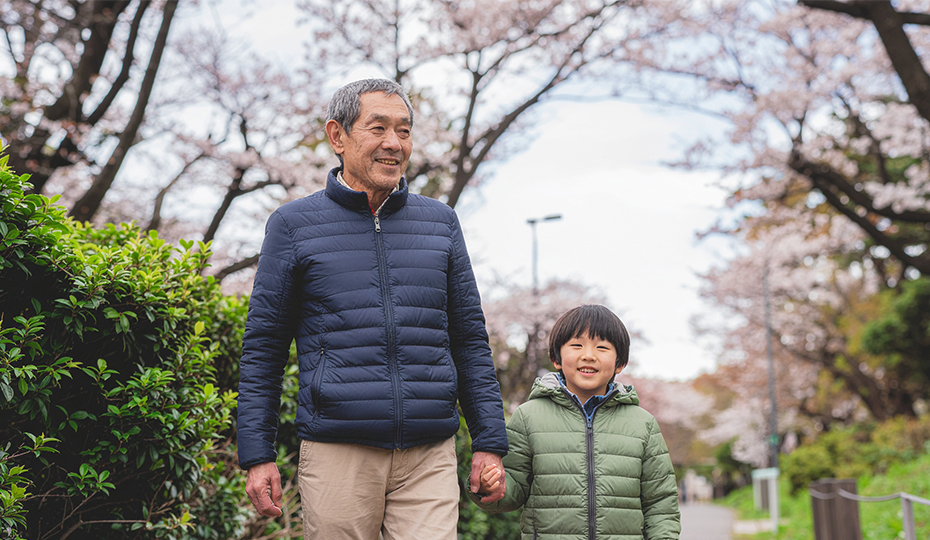 子供と手をつないで散歩する老人