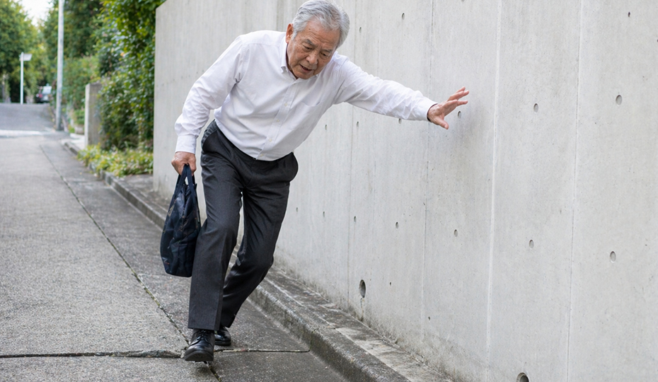屋外でつまづきそうになっている老人