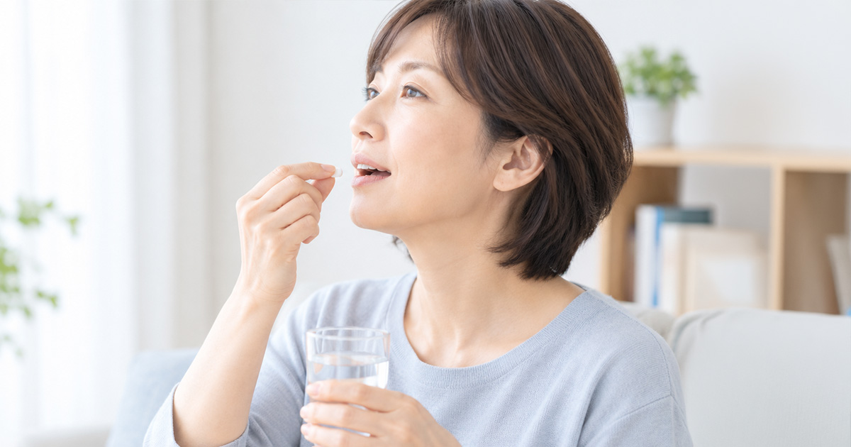 薬を飲む女性